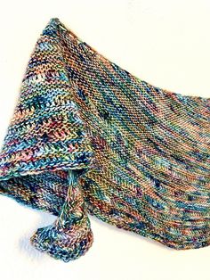 a multicolored knitted shawl on a white background