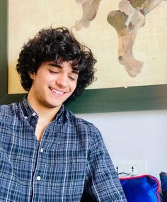 a man with curly hair sitting at a table