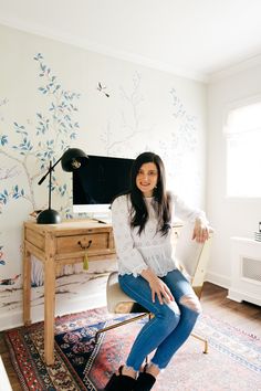 a woman sitting on a chair in front of a desk