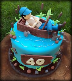 a birthday cake with a man in a boat on the top and number 40 on the bottom