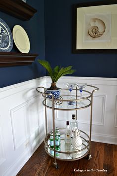 a bar cart with drinks on it in the corner