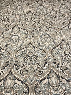 an intricately designed area rug is shown in grey and beige colors with black accents