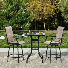 an outdoor table with two chairs around it