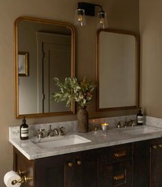 a bathroom with two sinks and mirrors in it