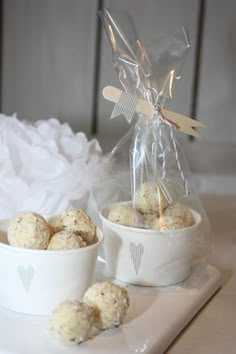 two white bowls filled with food sitting on top of a table next to a plastic bag