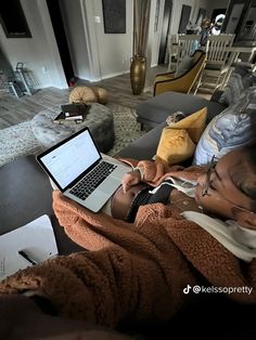 a woman sitting on a couch using a laptop computer