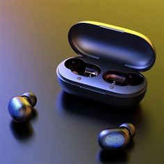 two earphones sitting next to each other on top of a black table with an orange and yellow background