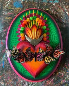 a heart shaped plate with butterflies and flowers on it, surrounded by other items in the shape of a flower