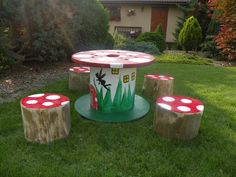 the table and stools are made out of tree stumps with painted mushrooms on them