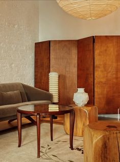 a living room filled with furniture next to a white brick wall and wooden paneled walls