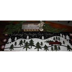 a christmas table runner with trees and snowflakes on it, saying believing through the snow