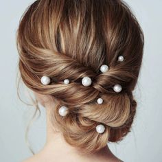 a woman with her hair in a low bun with pearls on the top and side