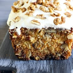 a piece of cake with white frosting and nuts on top