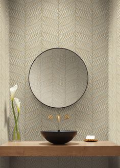 a bathroom sink sitting under a mirror on top of a wooden counter next to a vase with flowers