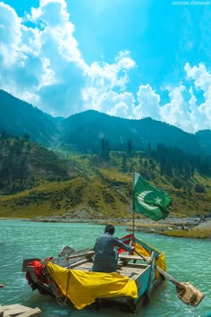 a man sitting on top of a small boat in the middle of a body of water