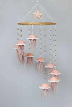 a pink and white jellyfish mobile hanging from a ceiling