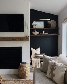 a living room filled with furniture and a flat screen tv mounted on the wall above a fire place