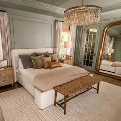 a bedroom with a bed, mirror and dresser