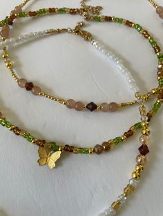 Look beautiful while embracing the spirit of nature with our Forest Fairy Necklaces. A unique blend of hand beaded glass in green, brown and gold, these necklaces are made of glass beads and 14K gold plated beads for lasting wear. Stand tall with nature. Green And Gold Beaded Necklace, Brown Beaded Jewelry, Nature-inspired Beaded Necklaces As Gifts, Nature-inspired Colorful Beaded Necklaces For Gifts, Nature-inspired Colorful Beaded Necklaces As Gift, Brown Czech Glass Beaded Chain Jewelry, Brown Czech Glass Jewelry With Beaded Chain, Nature-inspired Brown Beaded Necklaces, Nature-inspired Green Beaded Necklace With Round Beads