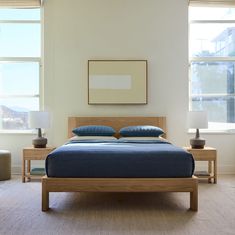 a bed with blue sheets and pillows in a bedroom