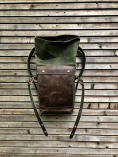 "This medium size backpack is made from waxed canvas in the color olive green with an outside pocket made in British waxed canvas color burned umber, with a layer of leather in front of the pocket. I made it into an everyday backpack/rucksack, with waxed canvas padded straps. Roll to close top, and outside pocket with protective flap. The bottom is made in oiled leather in the color brown. The bag closes with roll to close system and buckle and strap on the front in X-design made from vegetable Khaki Leather Backpack For Outdoor Activities, Waxed Leather Backpack For Hiking, Waxed Finish Leather Backpack For Hiking, Waxed Canvas Backpack For Hiking, Leather Backpack For Hiking With Waxed Finish, Rugged Waxed Canvas Standard Backpack, Leather Backpack With Leather Handles For Hiking, Leather Hiking Backpack With Leather Handles, Waxed Canvas Leather Backpack For Outdoor Activities