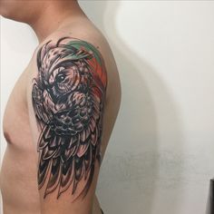 an owl tattoo on the left arm and shoulder