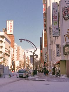 a city street filled with tall buildings and lots of signs on the side of it