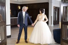 a man and woman are holding hands in a room with wood paneling on the walls