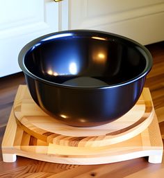 a black bowl sitting on top of a wooden tray