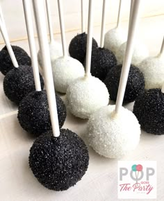 black and white cake pops are lined up on a table