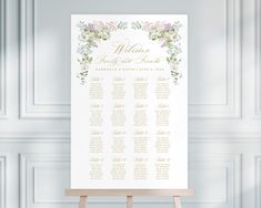 a wedding seating chart on an easel in front of a wall with white paneling