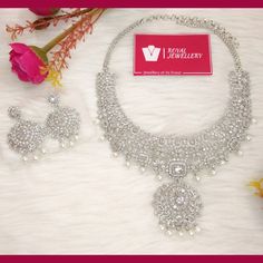 Beautiful American diamond heavy bridal necklace with earrings. Diamond set replica. High quality. Perfect for any occasion. More variety on our shop. Feel free to contact us for any enquiries. Please provide detailed address with contact number when order is placed as it is required on shipping label. Festive Silver Cubic Zirconia Bridal Sets, Silver Sets With Intricate Design For Reception, Heavy Kundan Bridal Necklace For Anniversary, Formal Diamond Chandbali Bridal Necklace, Bollywood Style Bridal Necklace With American Diamond For Reception, Heavy Dazzling Silver Necklace, Bollywood Silver Bridal Sets For Reception, Bollywood Style Silver Bridal Sets For Reception, Heavy Silver Bridal Necklace For Formal Occasions