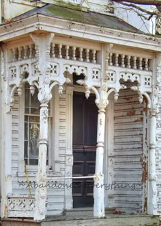 an old white house with columns and a door in the front porch is painted black