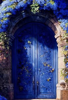 a blue door is surrounded by flowers and vines