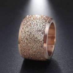 a ring with gold glitter on it sitting on a table next to a black surface