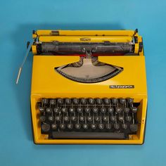 an old yellow typewriter on a blue background