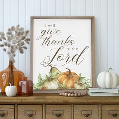 a wooden table topped with a vase filled with flowers and pumpkins next to a sign that says i will give thanks to the lord