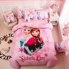 a pink bed with two cartoon characters on the covers and pillow cases, along with pillows