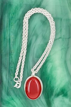 This carnelian pendant is bezel set on a cable chain. And this smooth, polished gemstone in burnished red makes a nice statement in a strapless style, office attire, t-shirt or sweater.

Size: The pendant length is 1", width is 11/16", gemstone is 25 x 18 millimeters, chain length 14”, chain width is 2.8 millimeters Gift Oval Cabochon Necklace With Polished Finish, Red Carnelian Oval Pendant Necklaces, Red Carnelian Oval Pendant Necklace, Red Carnelian Oval Necklace, Red Oval Carnelian Necklace, Red Oval Pendant Necklace With Spiritual Style, Red Oval Pendant Spiritual Necklace, Red Carnelian Necklace With Polished Finish, Carnelian Oval Pendant Necklace With Gemstone