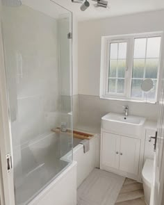 a bathroom with a sink, toilet and bathtub next to a window in it