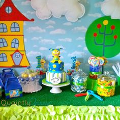 there is a birthday cake and candy bar set up on the table in front of the wall