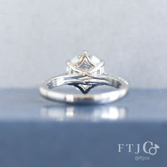 a close up view of a diamond ring on a blue surface with the words fit 6 written below it