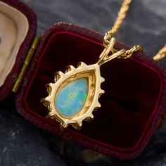 This mesmerizing pendant features a pear cabochon cut opal that is nicely encompassed by a beautiful halo of round brilliant cut diamond accents. The pendant is crafted from 14k yellow gold and hangs from a 24 inch 14k yellow gold rope chain. The opal has some light crazing, but is not very noticeable and does not distract from its great play-of-color. Formal Opal Teardrop Pendant Jewelry, Formal Teardrop Opal Pendant Jewelry, Gold Pear-shaped Halo Jewelry, Formal Opal Pear-shaped Jewelry, Pear-shaped Opal Jewelry For Formal Occasions, Formal Pear-shaped Opal Jewelry, Yellow Gold Teardrop Jewelry With Halo Setting, Yellow Gold Teardrop Halo Jewelry, Yellow Gold Opal Teardrop Pendant Jewelry