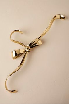 a pair of gold scissors on a white surface with the handles bent back to show the handle