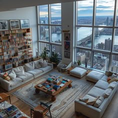 a living room filled with lots of furniture and large windows overlooking the cityscape