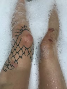 two people are laying in the bathtub with their feet covered by foamy water