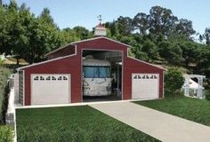 a large red barn with two garages and a bus parked in the door way