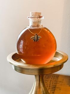 a bottle of honey sitting on top of a wooden stand