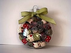 a glass ornament filled with lots of different types of buttons and bows on top of a table