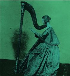 an old photo of a woman holding a harp